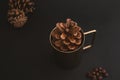 Pine cone in metal cupÃ¯Â¼Å with a background of coffee beans